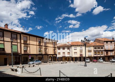 Visitors enjoy the historic Plaza Mayor in Berlanga de Duero, surrounded by charming architecture and a striking blue sky. Stock Photo