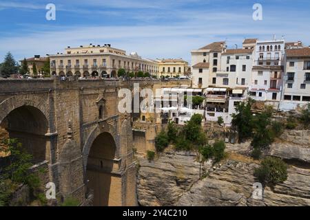 Old stone bridge and buildings built on the cliffs under a blue sky, El Puente Nuevo, the new bridge, old town, Ronda, Malaga, Andalusia, Spain, Europ Stock Photo