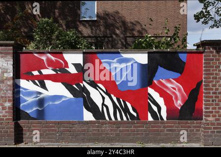 Abstract painting in blue and red colour on an old brick wall, decorative street art commissioned by the city of Duesseldorf, North Rhine-Westphalia, Stock Photo