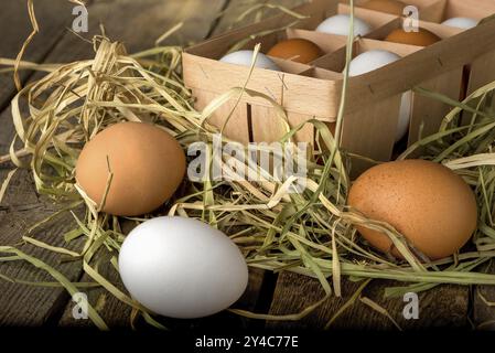 Egg tray in hay on a wooden table Stock Photo