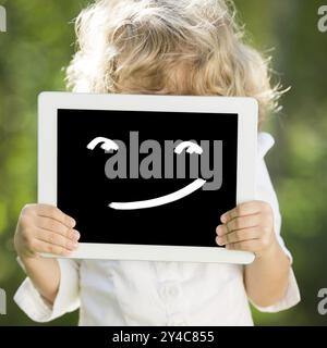 Child holding tablet PC with smile. Communication concept Stock Photo