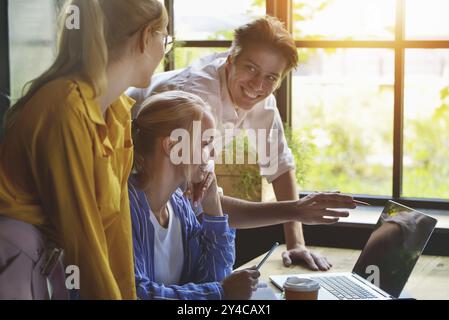 Group of colleagues having meeting in boardroom while working on big presentation and preparing their business strategy. Creative designers looking br Stock Photo