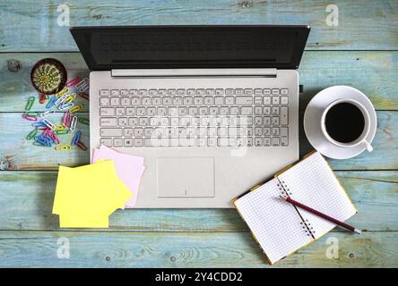 Laptop, stationary, cactus and cup of coffee on wooden table. View from above Stock Photo