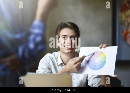 Photo of Interior designers teamwork with house building plans on office desk, architects working with many-color palette to choose best color for des Stock Photo