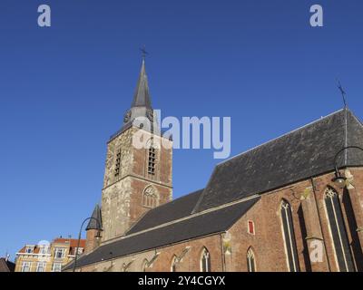 Gothic church with high steeple and red brick under a blue sky, winterswijk, the netherlands Stock Photo