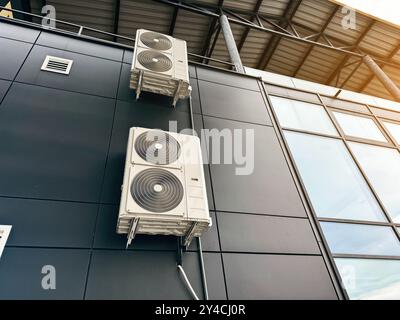 Commercial HVAC system installed on building exterior with glass, steel design Stock Photo