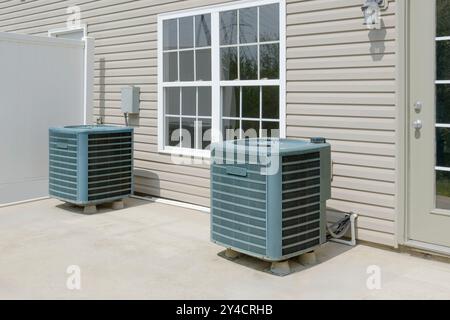 Horizontal shot of two external HVAC air conditioning units on a condo patio. Stock Photo