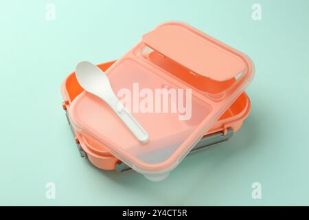 Empty lunch box with spoon on light blue background Stock Photo