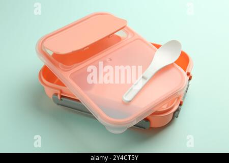 Empty lunch box with spoon on light blue background Stock Photo