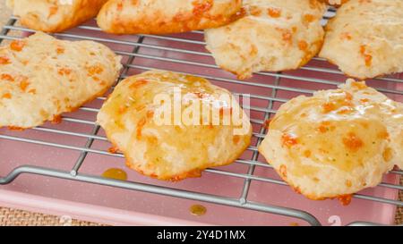 Fresh baked cheese biscuits close-up on a cooling rack. Stock Photo