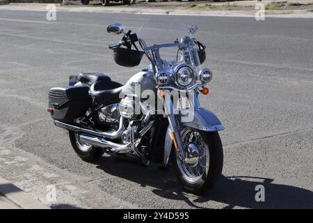 Classic silver motorcycle parked on a deserted street on a sunny day Stock Photo
