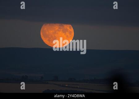 Edinburgh, Scotland. Tuesday 17th September, 2024. Blood moon over Edinburgh, glimpsed through partial cloud cover.  Credit: Brian D Anderson Stock Photo