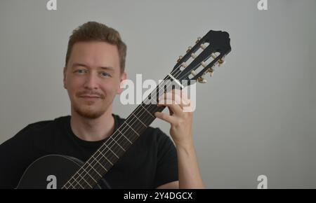 A man playing the guitar. Hands on the strings. Close-up portrait. Chord selection. Musician playing electric guitar. Banner wallpaper with copy space Stock Photo