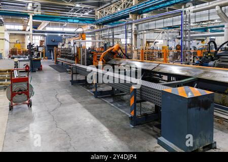 Metalworking factory production line. Production of metal profile cable canals. Stock Photo