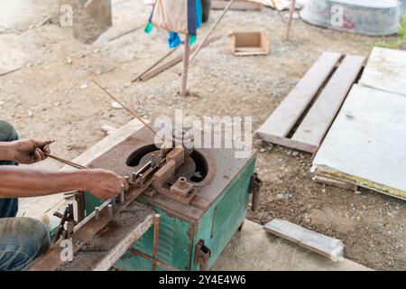 Worker hands working by using rebar bender machine reinforcing concrete metal at construction site Stock Photo