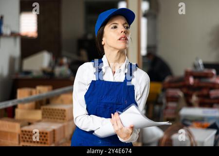 Female foreman making task list during works in building under construction Stock Photo