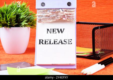 Text NEW RELEASE on a blank desktop calendar page on an orange background Stock Photo