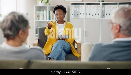 Therapy, tablet and therapist with couple on sofa for advice, consulting and counseling session. Psychology, talking and man and woman on couch for Stock Photo