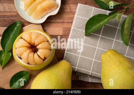 Fresh peeled pomelo with leaf on wooden table background for Mid-Autumn Festival fruit. Stock Photo