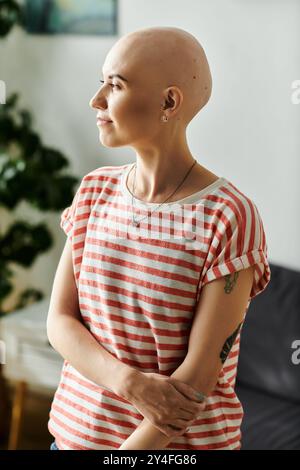 A beautiful bald woman stands gracefully, showcasing her unique charm and confidence. Stock Photo