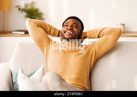 Happy Afro Man Relaxing Sitting On Sofa Indoor, Copy Space Stock Photo