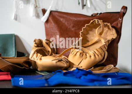 Craftspeople showcase various leather creations including bags and shoes. Stock Photo