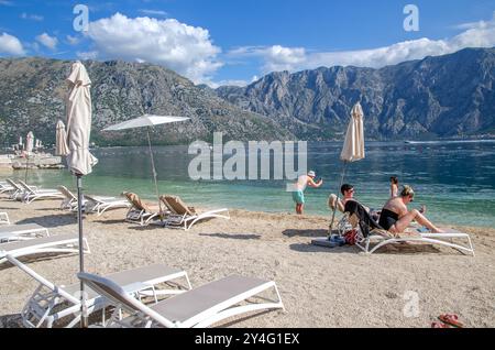 Tourists sunbathing and taking selfies on Stoliv beach, Kotor Bay, Montenegro, Europe Stock Photo