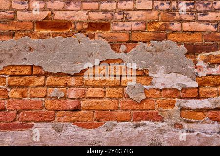 Weathered Brick and Peeling Plaster Texture Close-Up Stock Photo