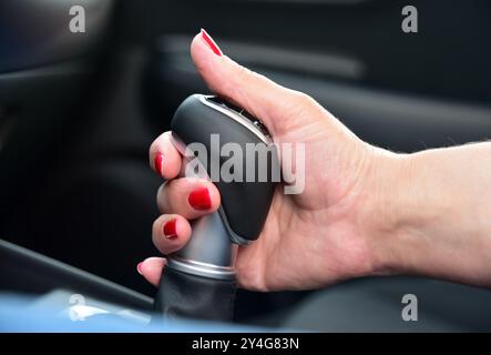 Female hand on automatic transmission lever, close up Stock Photo