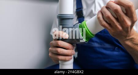 plumber installing PVC sewer pipeline. plumbing services. copy space Stock Photo