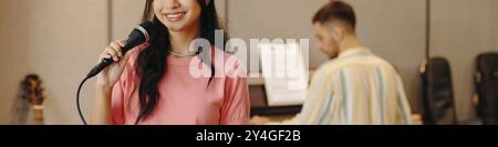 Young Woman Singing into Microphone in Music Studio Stock Photo
