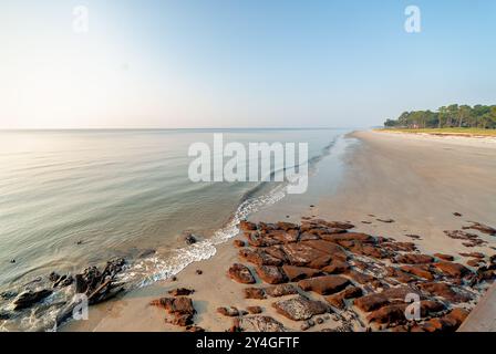 DAUFUSKIE ISLAND, South Carolina, United States — A pristine beach stretches out in front of a resort on Daufuskie Island, showcasing the unspoiled natural beauty of this secluded Lowcountry destination. The expansive sandy shoreline meets the waters of the Atlantic Ocean, offering visitors a tranquil coastal retreat. Stock Photo