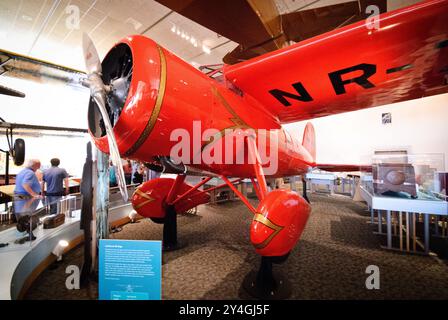 WASHINGTON DC, United States — Amelia Earhart's historic Lockheed Vega 5B (registration NR-7952) stands preserved at the Smithsonian's National Air and Space Museum. This distinctive red aircraft carried Earhart on her groundbreaking solo transatlantic flight in 1932 and her solo transpacific flight in 1935. The Vega represents one of the most significant aircraft in women's aviation history. Stock Photo