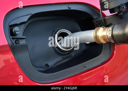 Refueling gun in tank filler. Fuel Nozzle in tank filler. Fuel pump in filler hole. Stock Photo