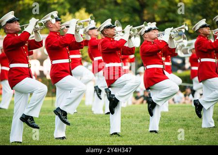 ARLINGTON, Virginia, United States — The United States Marine Drum and Bugle Corps, known as 'The Commandant's Own,' performs during the Sunset Parade at the Marine Corps War Memorial (Iwo Jima Memorial) in Arlington, Virginia. This stirring patriotic event, held adjacent to Arlington National Cemetery, showcases the precision and musical talent of the Marine Corps against the backdrop of one of America's most iconic war memorials. Stock Photo