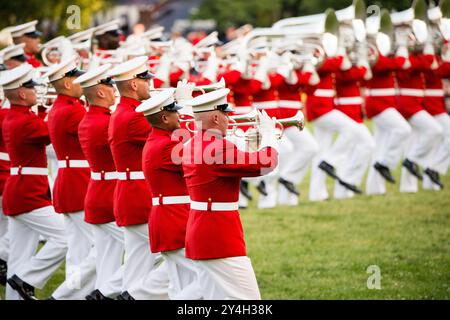 ARLINGTON, Virginia, United States — The United States Marine Drum and Bugle Corps, known as 'The Commandant's Own,' performs during the Sunset Parade at the Marine Corps War Memorial (Iwo Jima Memorial) in Arlington, Virginia. This stirring patriotic event, held adjacent to Arlington National Cemetery, showcases the precision and musical talent of the Marine Corps against the backdrop of one of America's most iconic war memorials. Stock Photo