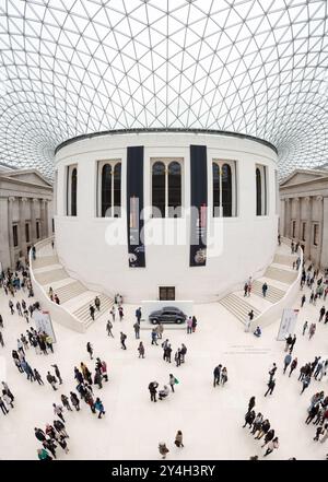 LONDON, United Kingdom — The Queen Elizabeth II Great Court at the British Museum in London. This two-acre covered square, designed by architect Norman Foster and opened in 2000, features a spectacular glass roof and serves as the central hub of the museum. The space encompasses the iconic Reading Room and provides access to various galleries and exhibitions. Stock Photo