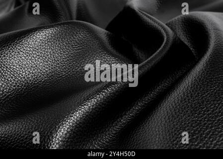 Texture of black wrinkled leather. Background of genuine leather with creases and folds Stock Photo