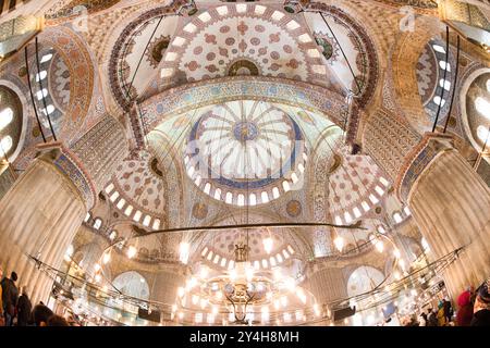 ISTANBUL, Turkey — Intricate Islamic decoration covers the walls and ceiling of the Sultan Ahmed Mosque's (Blue Mosque) main prayer hall. The mosque, completed in 1616, features extensive use of hand-painted tiles and calligraphy in its interior design. The space demonstrates the height of Ottoman architectural and decorative achievement during the early 17th century. Stock Photo