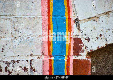 Vibrant Vertical Stripes on Textured Brick Wall Eye-Level View Stock Photo