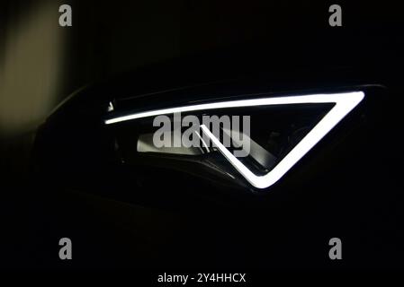 Activated headlights of a modern car. Photographed at night. Car head lamp. Close-up shot of car head lamp. Detail on the outside of the car. Stock Photo