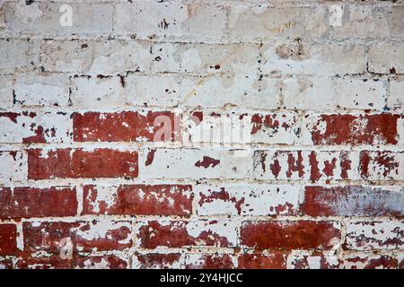 Weathered Red Brick Wall with Peeling Paint Close-Up Stock Photo