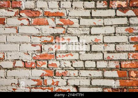 Weathered Brick Wall with Peeling Paint Texture Eye-Level View Stock Photo