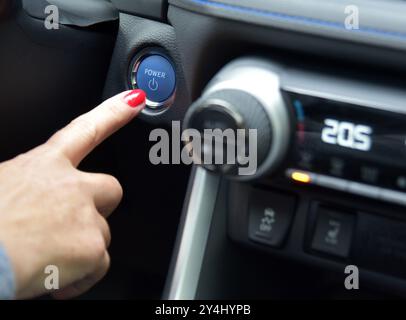 Women activates button to start and stop for car engine Stock Photo