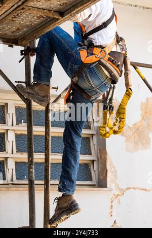 Brazilian construction worker climbing a scaffolding in a home restoration site in Belo Horizonte, Brazil. Stock Photo