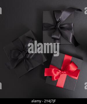 Black Friday Sale. Black gift boxes with ribbon bow isolated on black, top view Stock Photo
