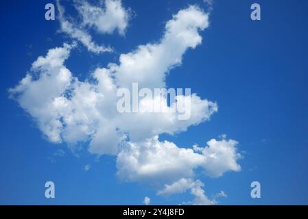 white cumulus clouds ruffled by the strong wind in the blue sky Stock Photo