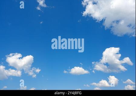 white cumulus clouds ruffled by the strong wind in the blue sky Stock Photo