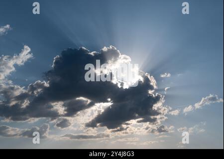 Sun behind a cloud with rays of light Stock Photo