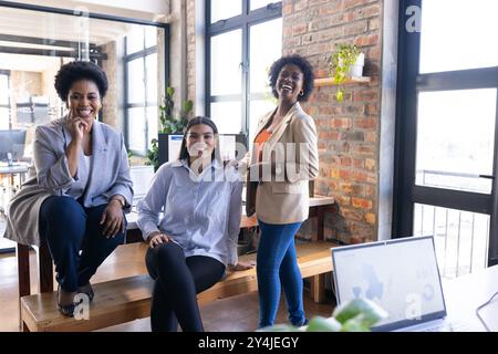 Smiling businesswomen in modern office, collaborating and discussing project ideas Stock Photo